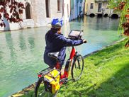 Radlerin mit E-Bike an Fluss in Treviso