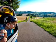Familie radelt entlang dem Weser-Radweg mit einem Kinderanhänger