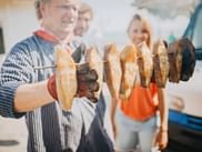 Göhren: Verkäufer zeigt Fischspezialitäten