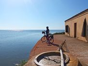 Radlerin mit Fahrrad schaut aufs Meer beim Casone Donnabona