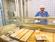 Alter Mann in Nudelgeschäft vor Theke mit frischer Pasta