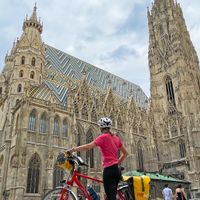 Eine Radfahrerin steht vor dem Stephansdom in Wien