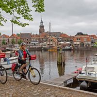 Two cyclists ride along the harbour of Weerribben-Wieden