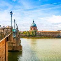 View over a bridge to the historic Hospital La Grave in Toulouse
