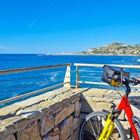 Radfahrerin am Meer mit wunderschöner Aussicht auf die nächste Ortschaft