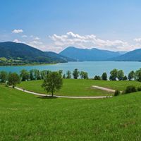 View across meadows to Lake Tegernsee with the mountains in the background
