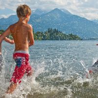 Drei Kinder spritzen im Wasser im Zeller See