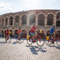 Group of cyclists in front of the Arena in Verona
