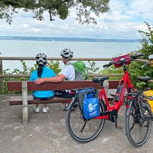Radfahrer auf Bank mit Blick auf den Bodensee