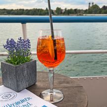 Aperol on the ferry with a lake in the background