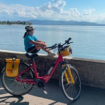 Cyclist with bicycle on the shores of Lake Constance