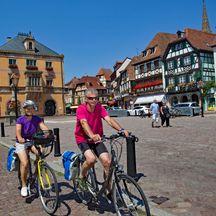 Radfahrer radeln durch ein typische Kleinstadt im Elsass