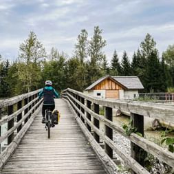 Cyclist on wooden bridge on the Drau