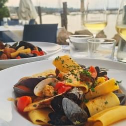 Pasta mit Meeresfrüchten und einem Glas Wein dazu