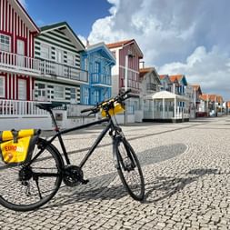 A bicycle in front of the colourful wooden houses of Praia da Costa Nova