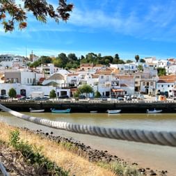 View of fishing village in Algarve with white houses and blue sky