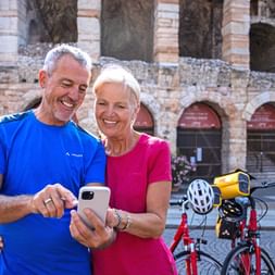 Cyclists with a phone in front of the arena in Verona