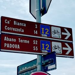 Brown bike path sign pointing to Abano Terme
