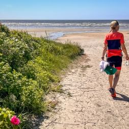 Radfahrerin spaziert am Strand in Smaris