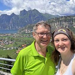 Father and daughter take a selfie on a viewing terrace near Nago overlooking Lake Garda.