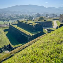Star-shaped fortress walls of Valença with green grass slopes overlooking the town and mountains in Alto Minho, Portugal.