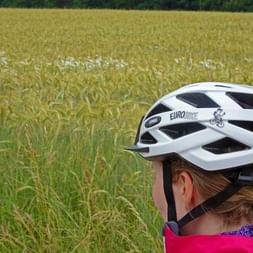 Cyclist with Eurobike bike helmet in front of field