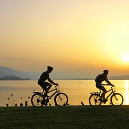 Cyclists at the lake at sunset