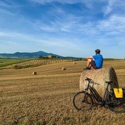 Cyclist resting on hay bales