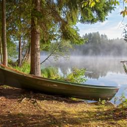 Morning atmosphere on the lake with a rowing boat on the shore