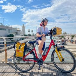 Radfahrerin mit Leihrad auf Brücke in Italien