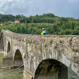 Radfahrerin blickt von Brücke
