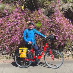 Cyclist in front of a flowering bush