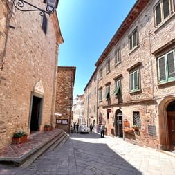 Old town alley with brick houses in Tuscany and cobblestones streets