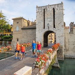 Cycling group on a walk on the castle bridge in Sirmione