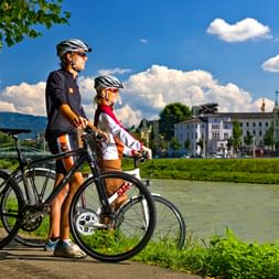 Two cyclists look out over the Salzach