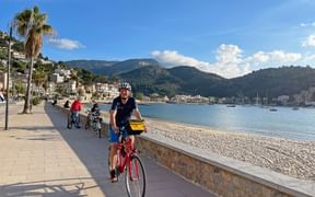 Cyclists on the paved cycle path along the beach of Port de Soller