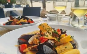 Pasta mit Meeresfrüchten und einem Glas Wein dazu