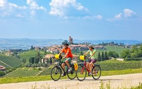 Zwei Radfahrer auf einer kleinen Straße mit Blick auf Montforte und das Umland