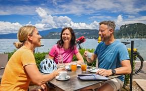 Coffee break for three cyclists in Bardolino with a view of Lake Garda