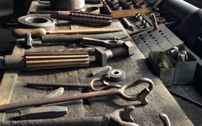 Collection of vintage industrial mining tools from Zeche Nachtigall in Witten, including wrenches, hammers, and metal working equipment.