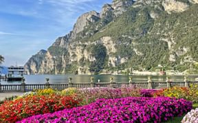 Blumenpracht in Riva del Garda mit Blick auf den Gardasee und die Berge