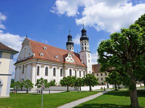 Stiftskirche mit Wiese und Bäumen in Obermarchtal