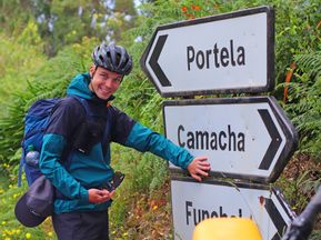 Cyclist in front of signpost pointing to Camacha