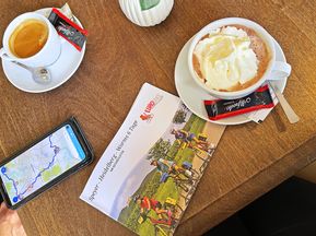Reiseunterlagen und Tassen Kaffee in einem Café in Ladenburg