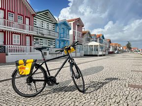 A bicycle in front of the colourful wooden houses of Praia da Costa Nova