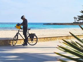 Cyclist with bike in front of the sea