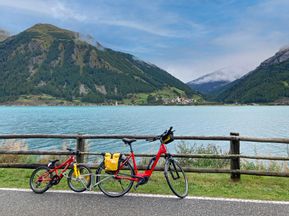 Bikes by the lake against a mountain backdrop