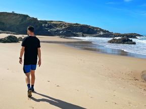 Mann spaziert am Strand entlang