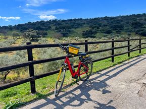 Bike leaning against a fence with a view of the Andalusian countryside