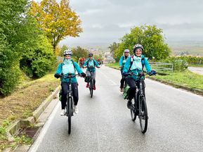 Radlergruppe bei Aufstieg durch Weinberge